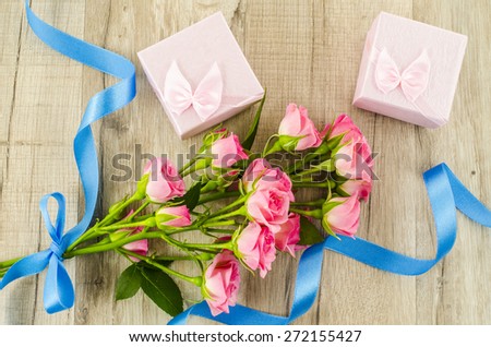 Rose flower and gift box on wooden background