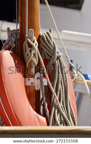 a lifebuoy on a boat mast behind ropes