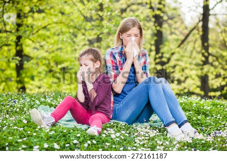 Two people with allergy symptom blowing nose Royalty-Free Stock Photo #272161187