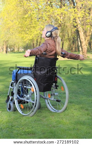 A Woman happy in a wheelchair with arms spread