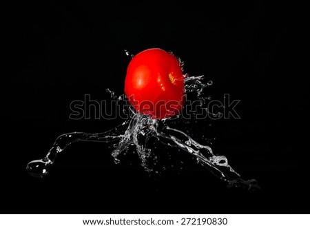 Tomato on a black background with a current of water.