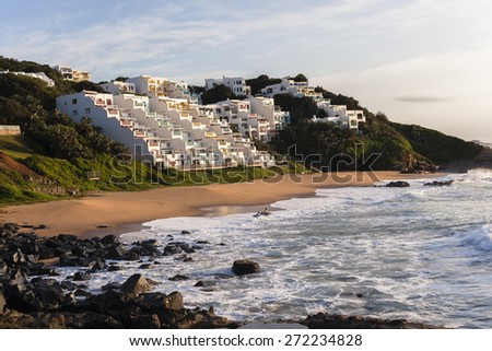 Beach Coves Apartments Holidays
Small beach rocky coast cove for holidays swimming surfing ocean waves with  apartment houses on the landscape