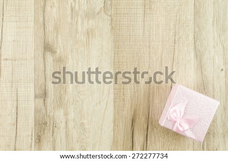 Gift box and ribbon on wooden background