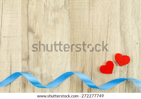 Heart and ribbon on wooden background