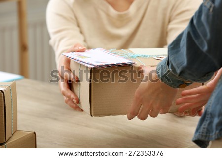 Woman gives parcel in post office Royalty-Free Stock Photo #272353376