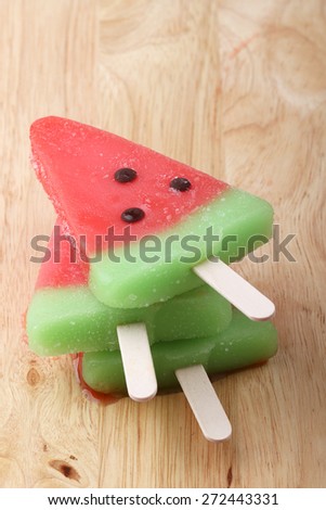 watermelon shaped ice cream pops stack on wooden plate