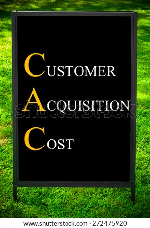 Business Acronym CAC as CUSTOMER ACQUISITION COST. Message on sidewalk blackboard sign against green grass background. Concept image