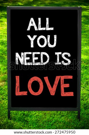 ALL YOU NEED IS LOVE  message on sidewalk blackboard sign against green grass background. Copy Space available. Concept image