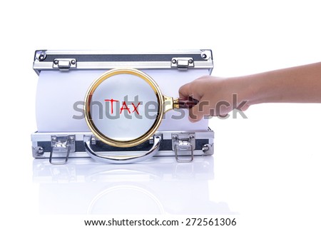 Hand Holding Magnifying Glass on box and Write "TAX", Focus on paper.
