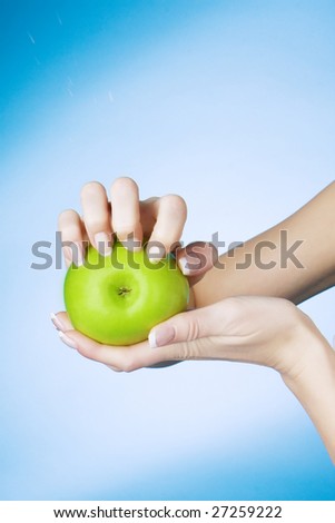 Picture of a girl who seized nails the green apple on a blue background