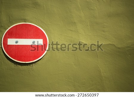 No entry sign attached to yellow brown painted wall