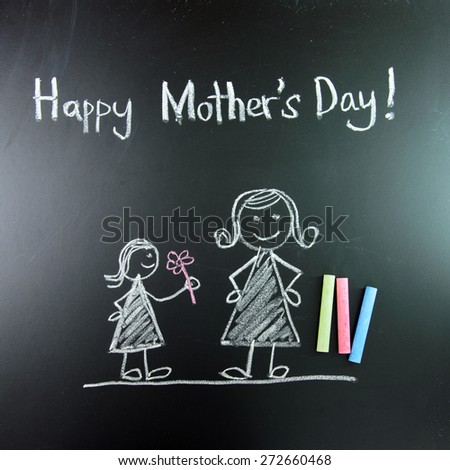 Child drawing of happy mother's day picture using chalk on blackboard