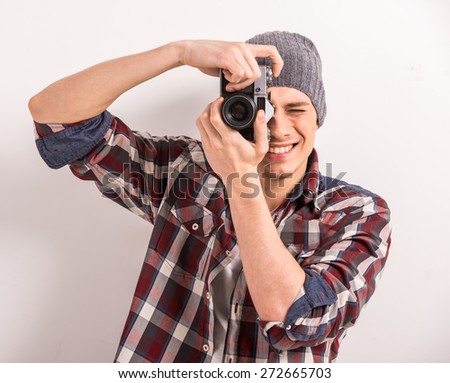 Young man is taking a picture with an old camera.