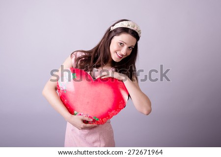Portrait of beautiful young lady with heart shaped present box