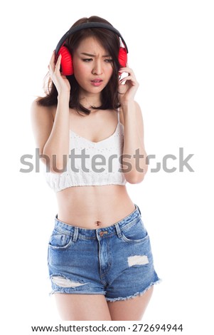 Young serious woman  and not enjoy listening to music with headphones on white background