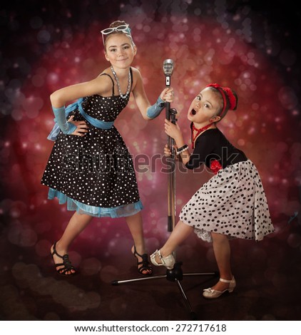 Rockabilly girls singing on a colorful background with glowing lights
