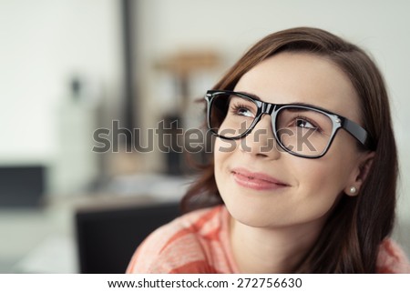 Smiling Young Woman Wearing Eyeglasses with Black Frames and Looking Up as if Daydreaming or Thinking of Something Happy Royalty-Free Stock Photo #272756630
