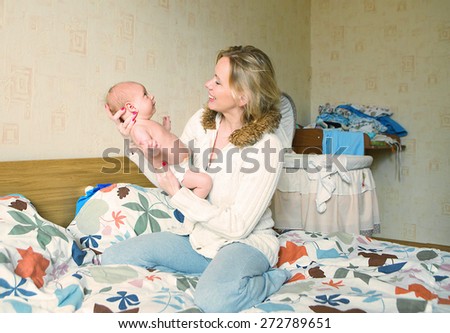 Mother with her newborn baby care hands at home