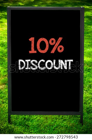 TEN PERCENT DISCOUNT  message on sidewalk blackboard sign against green grass background. Copy Space available. Concept image