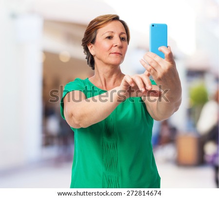 portrait of a mature woman taking a photo with her mobile