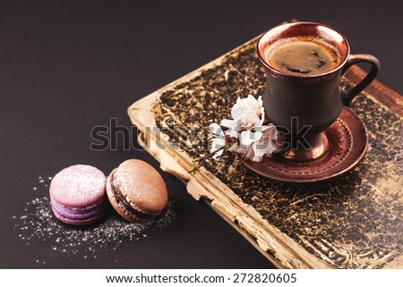 Vintage coffee with flower and macaroons on black backgrownd