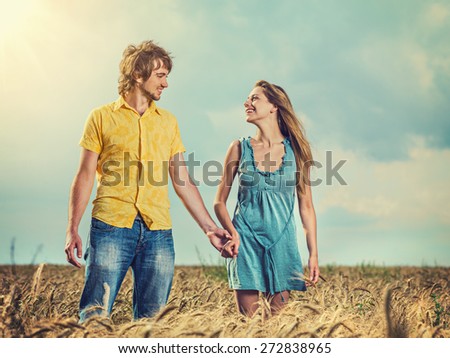 Couple at sunset on the countryside. Young romantic man and woman in the wheat field. Young love concept. Instagram effect.