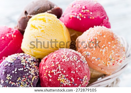 Ice cream scoops on wooden table, close-up.