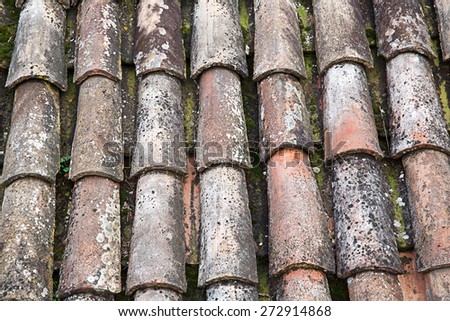 View of unique, weathered terracotta roof of a Mediterranean house. Textured effect background. Construction, home, protection and travel concept. 