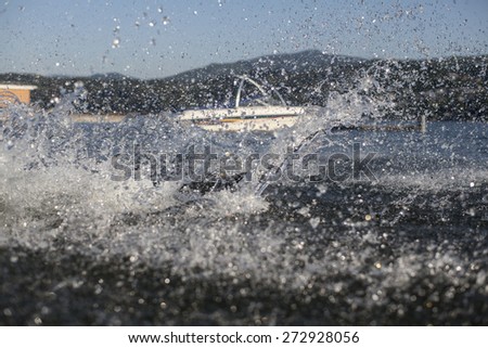 Summertime Splash Swimming in a Lake with a Ski or Wakeboard Boat in the Background