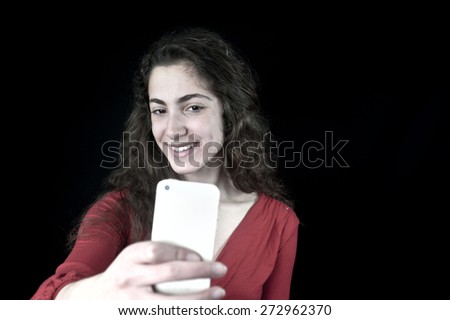 Young female holding a smartphone taking selfie