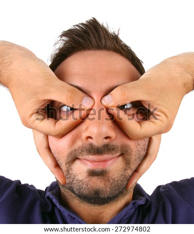 Toung man winces with his hands over his eyes on white background.