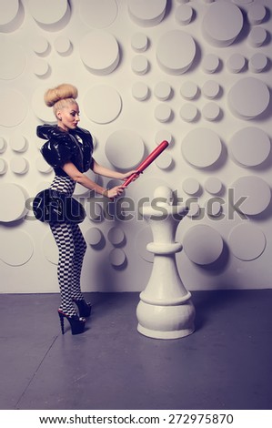 Woman in the form of a Chess Queen. Costume party. Halloween. Make up on the woman's face. Emotions girl on the face. Entertainment in the night club. Hold the bat for baseball in his hand. 