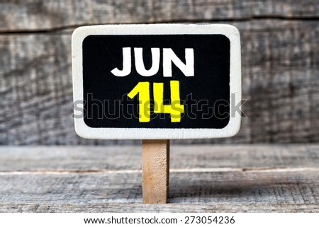 June 14 written on blackboard on a wooden background