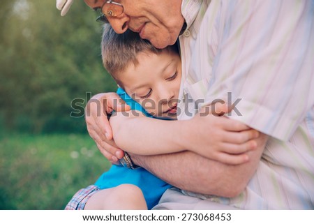 Portrait of happy grandson hugging grandfather over a nature outdoor background. Two different generations concept. Royalty-Free Stock Photo #273068453