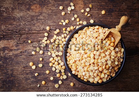 Bowl of yellow dry split peas on wooden background Royalty-Free Stock Photo #273134285
