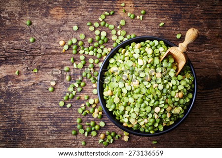 Bowl of green split peas on wooden background Royalty-Free Stock Photo #273136559