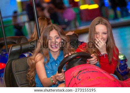 kids or teens on fairground ride dodgem bumper cars    Royalty-Free Stock Photo #273155195