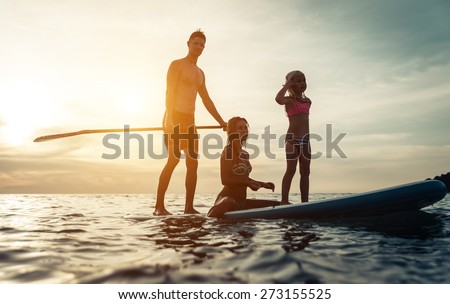 surfing. happy family silhouette on the paddle board. concept about family, sport and fun Royalty-Free Stock Photo #273155525