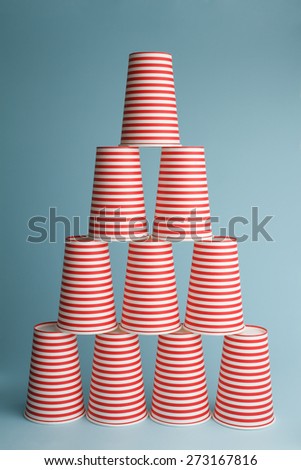Pile of drinking party cups on blue background