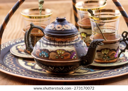 Close-up view of traditional Turkish tea set: vintage glass cups with teapot on the plate