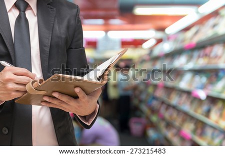 Businessman writing the note book on Abstract blurred photo of book store with people background