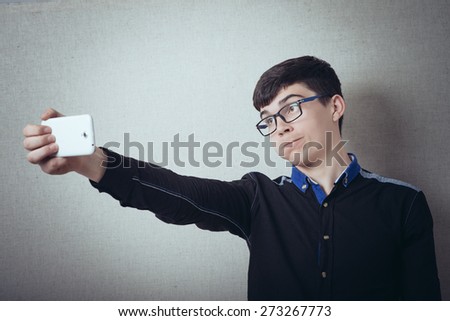 The man is photographed on the phone, Selfie. On a gray background.