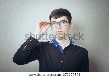 Serious man in glasses. On a gray background.