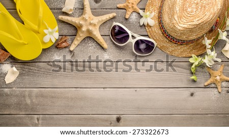 Straw hat,sunglasses and beach slippers on wood
