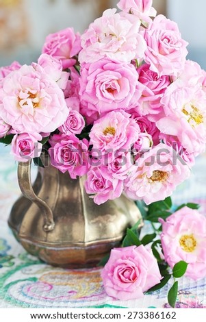 Arrangement with fresh pink roses on a table.
