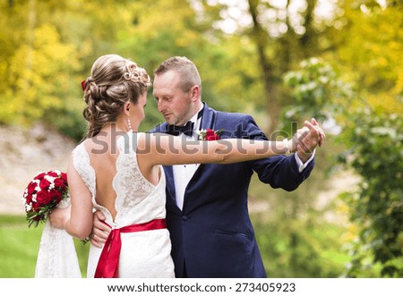 Young wedding couple enjoying romantic moments outside in summer park