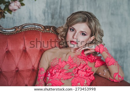The girl in a transparent pink dress on a sofa.