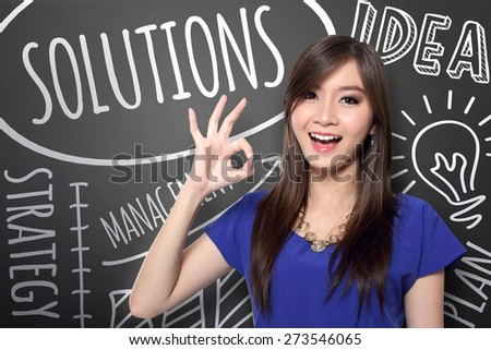 Happy young Asian woman with big bright smile making okay hand gesture on hand drawn business concepts doodle background
