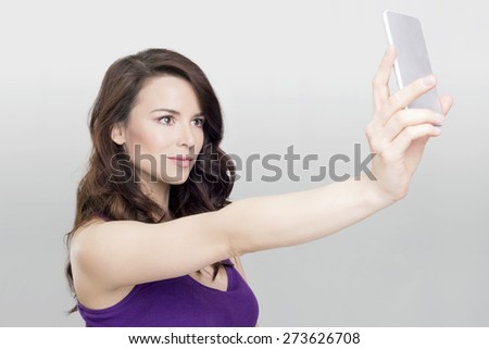 Beautiful woman taking a photo of herself with a cell phone