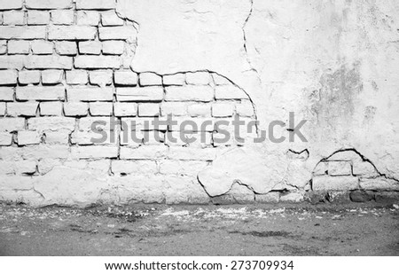 Abstract urban courtyard interior with white damaged brick wall and asphalt pavement